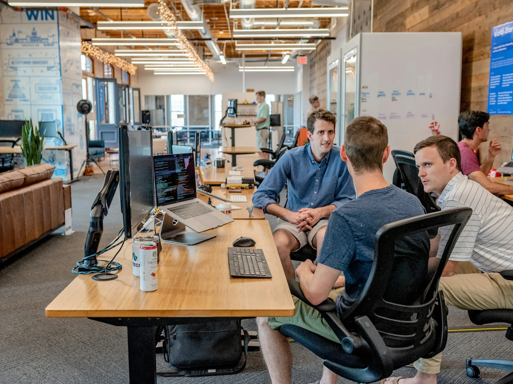 A small group in a focused working session around a meeting table.