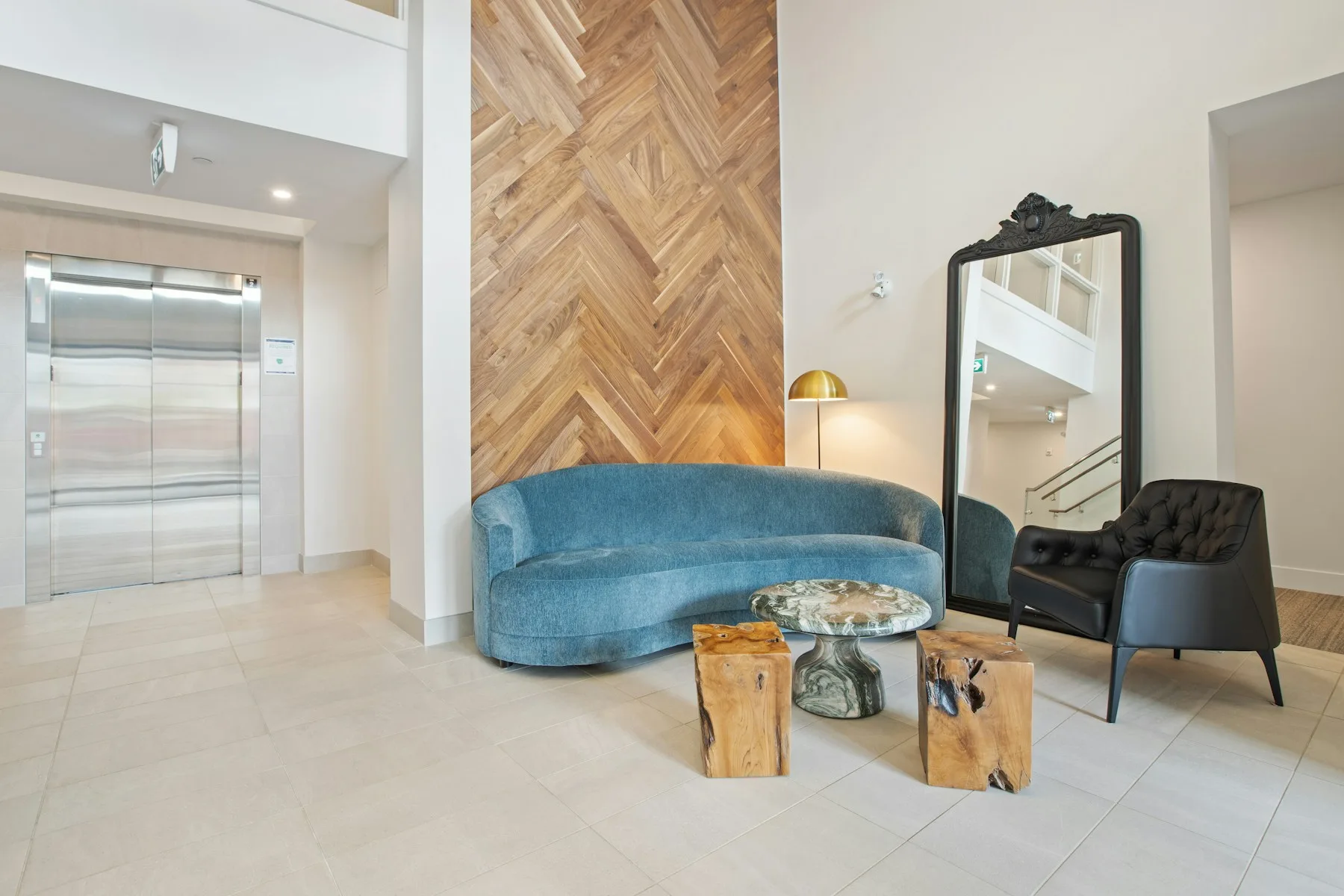 A calm residential lobby with seating and elevator access.