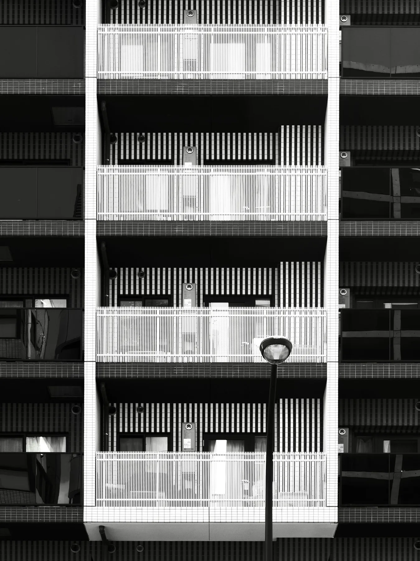 A newly finished residential building with balconies and landscaped frontage.