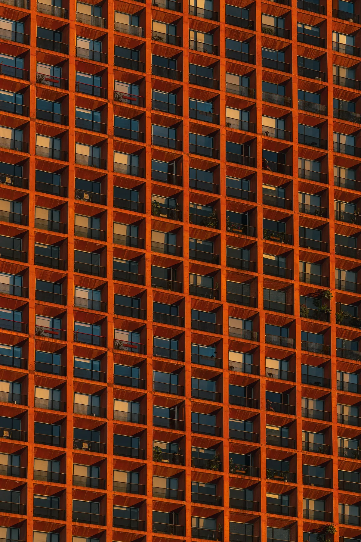 A modern residential building facade with a precise grid of balconies.